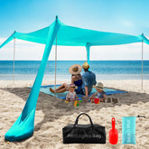 Aporio Beach Tent Sun Shelter 10x10 setup on sand provides cool shade for a family day