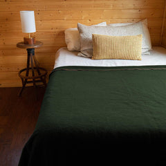 Arcturus military wool blanket olive-green draped over a backpack outdoors