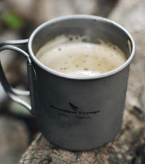 Boundless Voyage titanium cup on camping stove heating outdoors.