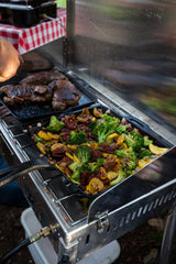 Camp Chef Mountaineer lid folds for transport and wind protection during use.