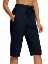 DEVOROPA hiking shorts front view with navy fabric and zip pockets for secure storage
