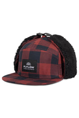 Flylow Walleye Cap with fleece-lined earflaps in buffalo plaid, ideal for cold days outdoors.