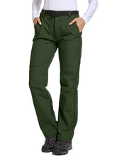 Jessie Kidden women's waterproof pants forest gear display shows rugged protection for outdoor adventures.