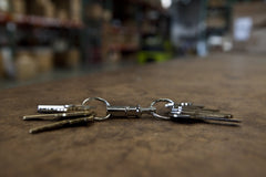 KEY-BAK chrome cylinder key holder features pull-apart design to separate home and work keys.