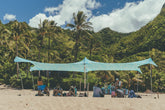 Neso Aqua Fronds party tent front view provides shaded beach space.