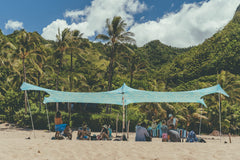 Neso Aqua Fronds party tent front view provides shaded beach space.
