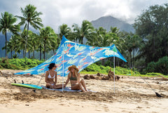 Neso portable beach tent in use with sand anchors delivering stable shelter by waves.