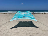 Neso Swells beach tent fully set up on beach providing family shade