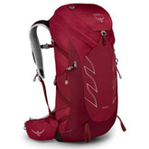 Osprey Talon 36L backpack with cosmic red hipbelt, stabilizing load on rugged trails.