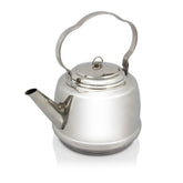 Petromax stainless steel teakettle over an open flame for quick hot beverages