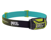 Petzl ACTIK CORE headlamp on head in green for hands-free outdoor lighting.