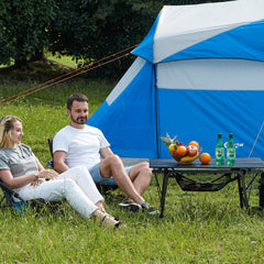 Portal camping table adjustable legs extended for stable use on uneven ground.