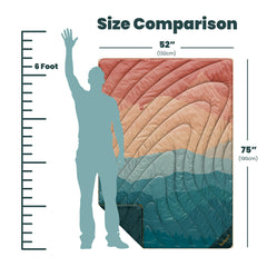 Rumpl Original Puffy Blanket cape-clip in use provides hands-free warmth.