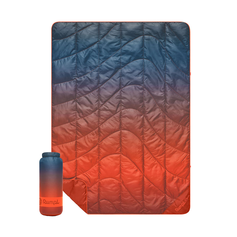 Rumpl Travel Puffy Blanket Volcanic Fade folded in roll-top sack for easy transport.