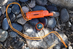 SE orange survival whistle features a waterproof compartment for small items.