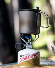 Snow Peak Trek 700 pot nestled with gear shows space-saving setup in a camp kit.