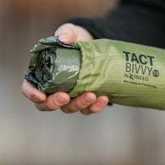 Survival Frog Tact Bivvy HeatEcho emergency bag with drawstring paracord and fire-start capability.