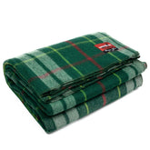 Swiss Link Military Surplus wool blanket in green plaid folded for easy storage and warmth.