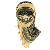 Texas Bushcraft tactical shemagh desert scarf in khaki shields face from dust and sun.