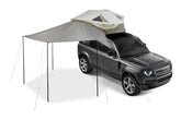 Thule Approach Awning L gray side setup provides shaded outdoor space.