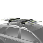 Thule SnowPack Large loading skis on roof, secure and ready for a winter trip.