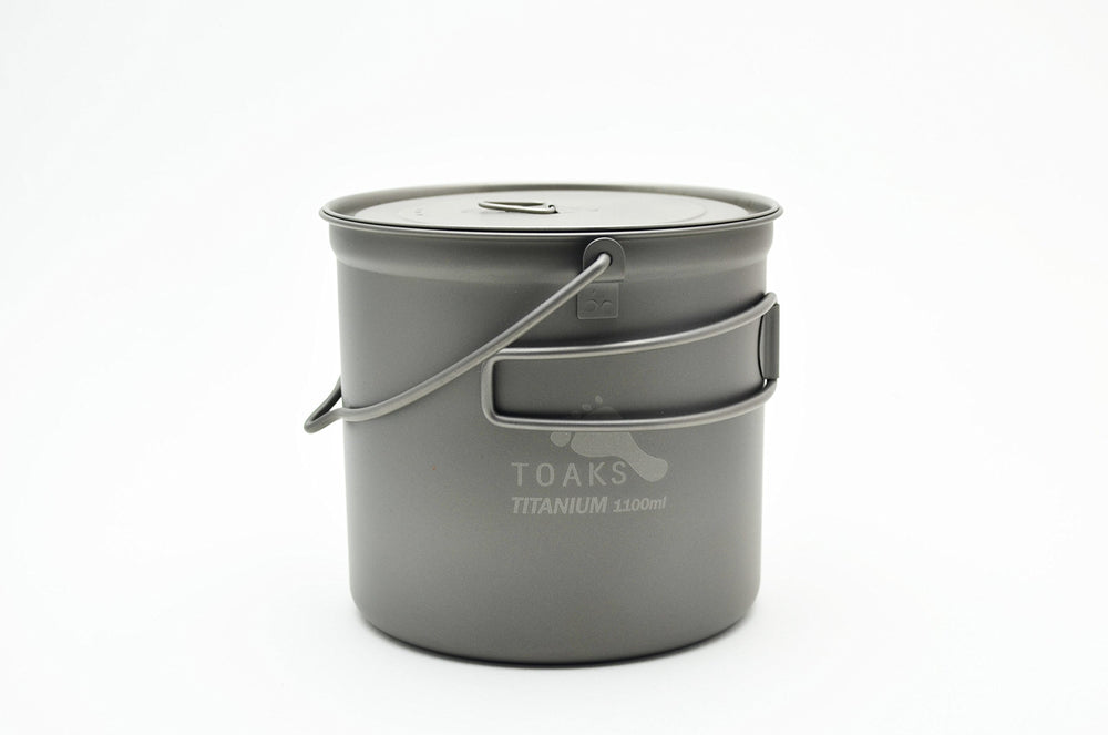TOAKS titanium 1100ml bushcraft pot with bail handle, ready for open-fire cooking.