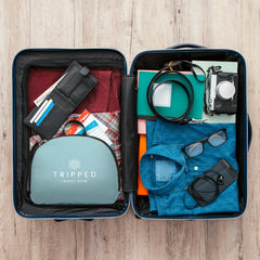 TRIPPED Travel Gear teal foldable backpack back view with luggage strap for easy airport transitions.