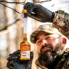 Wildlife Research Center Key-Wick beside scent bottle showing compact form.