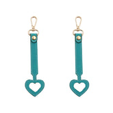 YEZILUU heart-shaped hat clip in dark blue vegan leather demonstrates secure hands-free storage.