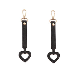 YEZILUU heart-shaped hat clip in black secures a cap on a backpack.