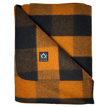 Arcturus Backwoods Wool Blanket 64x88 on bed offers warm comfort for camping.