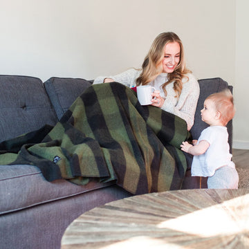 Arcturus Backwoods Wool Blanket outdoors scenario illustrates sharing warmth with a friend.