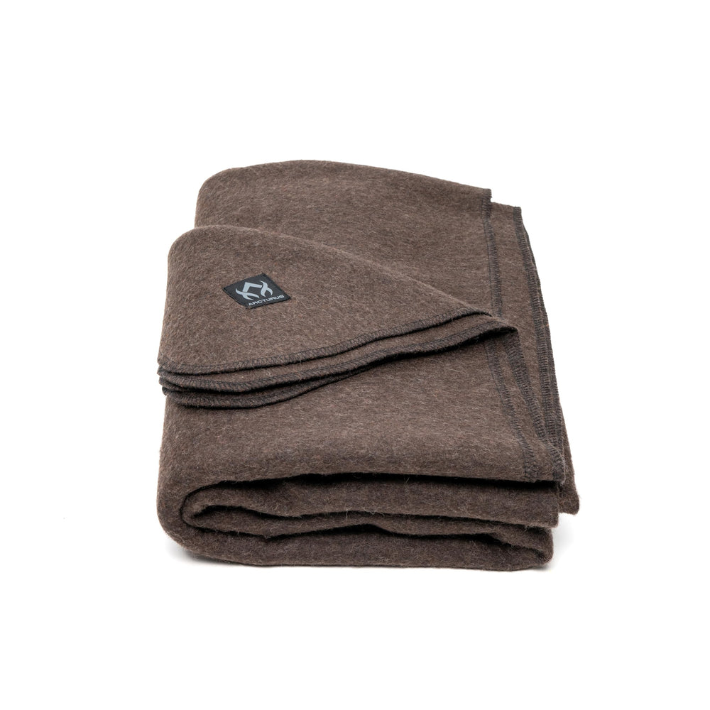Arcturus Military Wool Blanket on campsite at dusk, offering generous warmth for two.