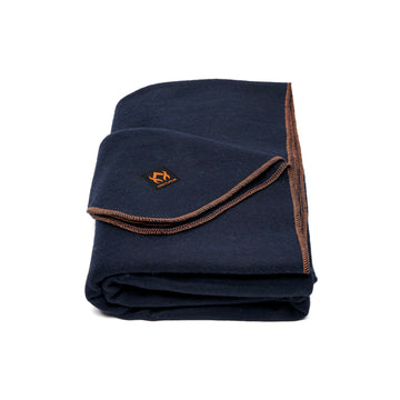 Arcturus military wool blanket folded on campsite for outdoor warmth.