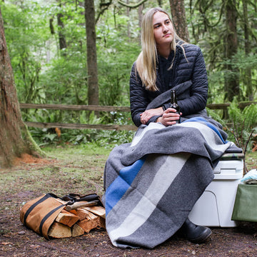 Arcturus Rainier Blanket outdoors with gear, ready for chilly nights.