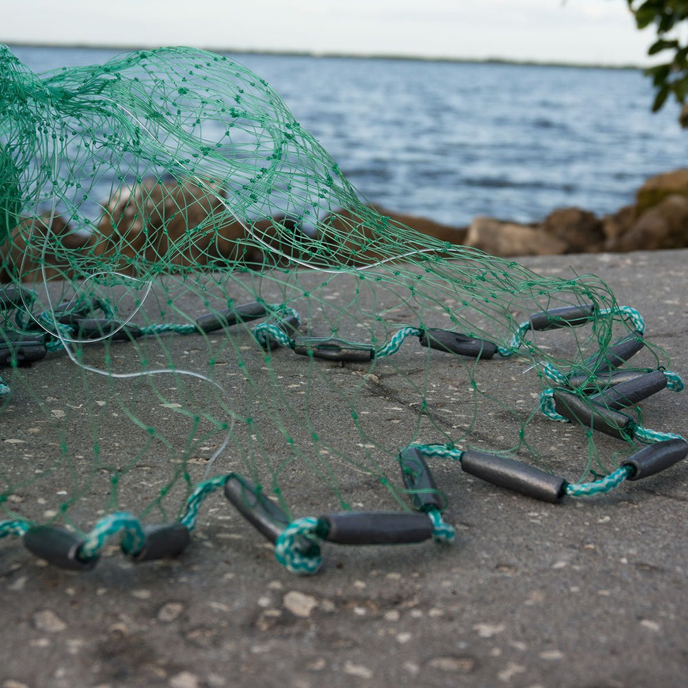 Close-up of 1-1/4 in square mesh on Bait Buster Mullet Cast Net with packaging