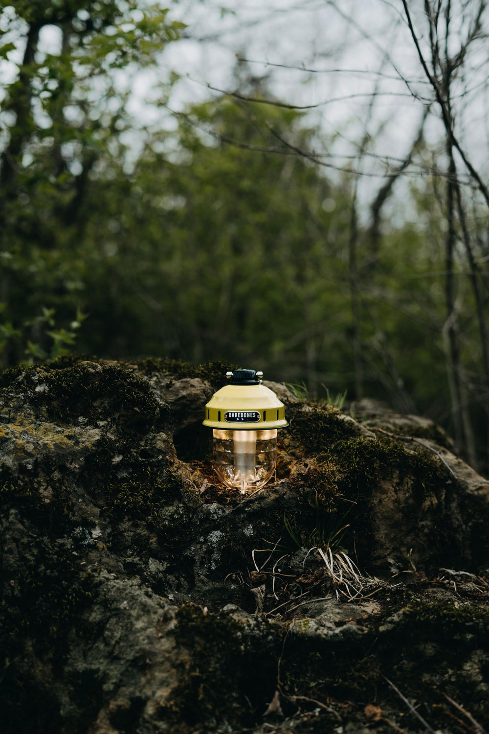 Barebones Beacon Hanging Light dusty yellow glow on porch for cozy evenings