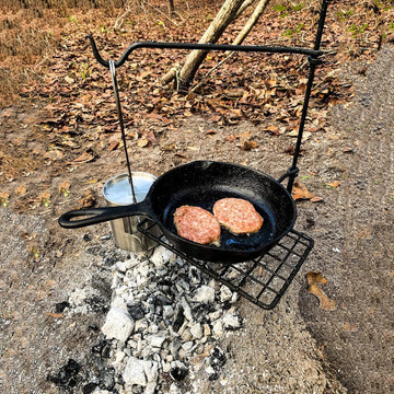 BATTLBOX Bushcraft Grill Set in use with a skillet on the grill surface.