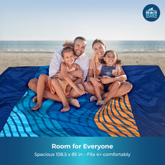 Beach Dudes Blue Waves blanket with stakes in use, wind-secure on breezy days.