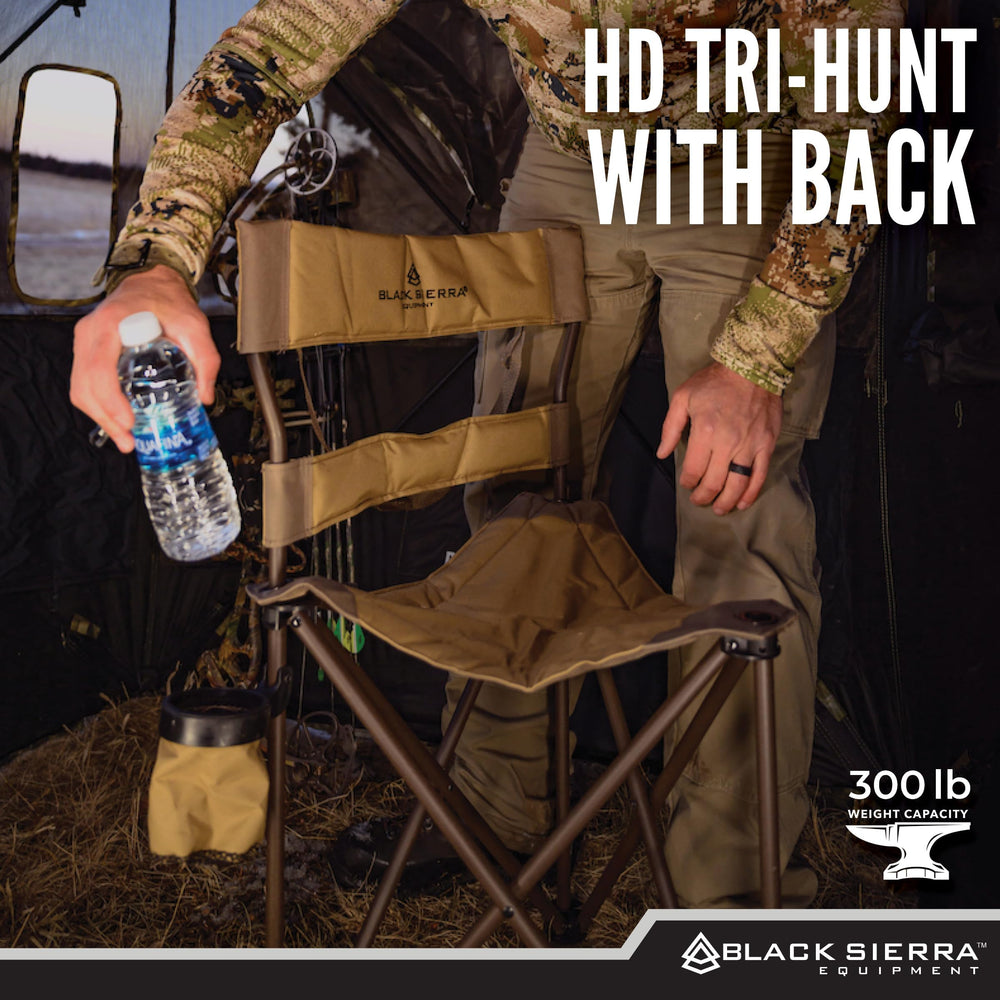 Black Sierra Equipment XL tripod hunting stool on rugged terrain shows stable seating.