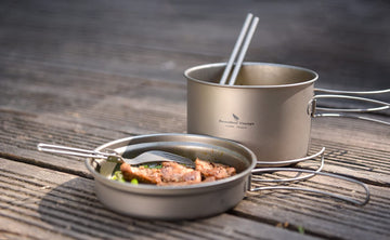 Boundless Voyage campfire-ready titanium set in action during a sunset cook.