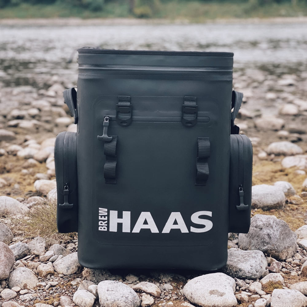 Stainless steel bottle opener attached to BREW HAAS backpack cooler for outdoor use