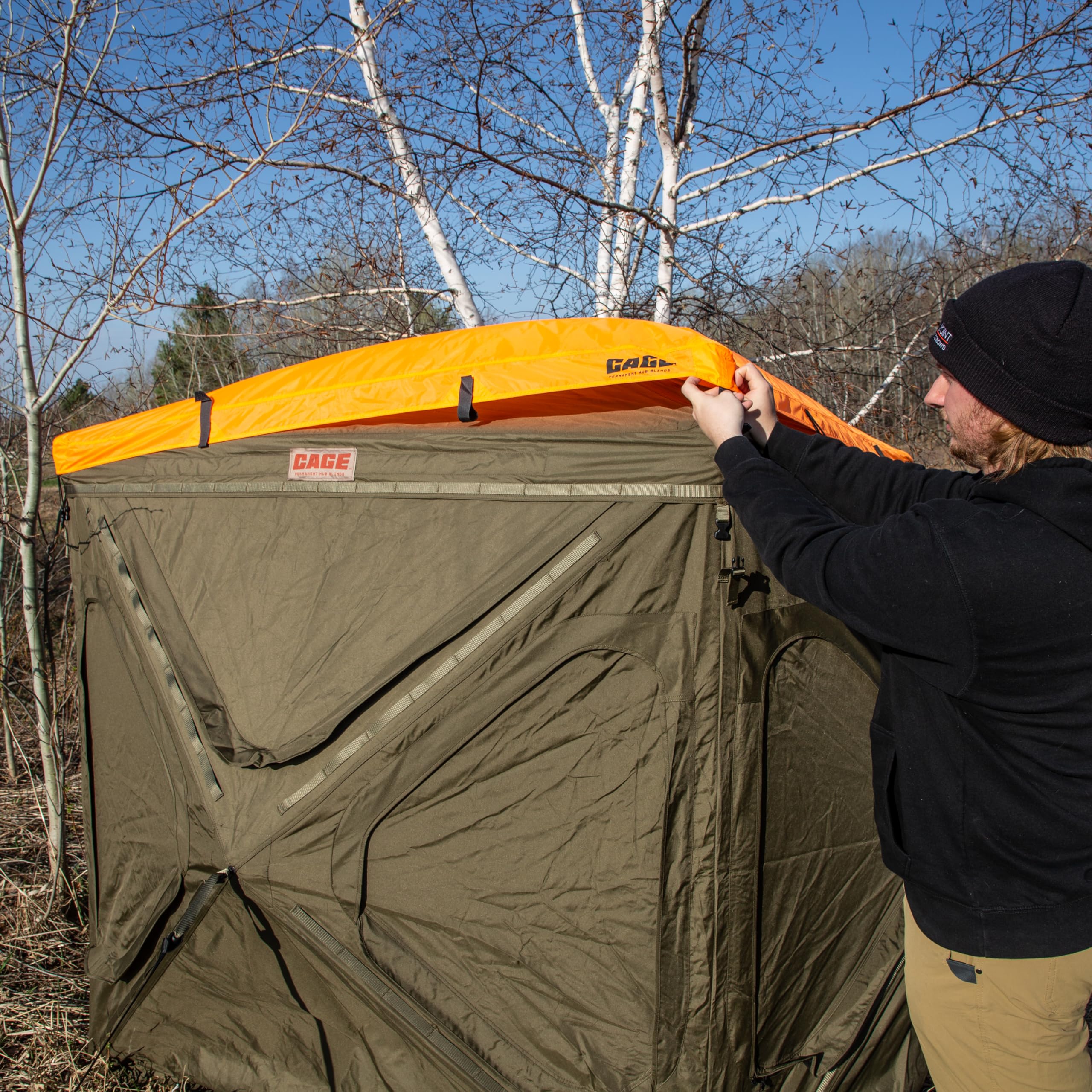 CAGE Blaze Orange Safety Cap showing hook-and-loop perimeter securement around brush holders