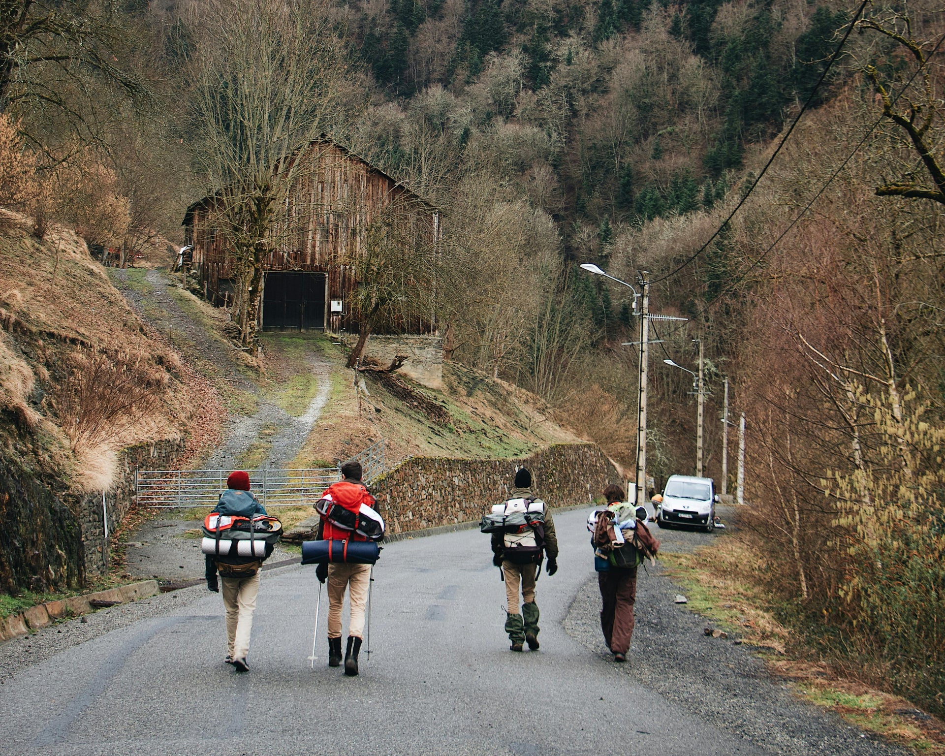 Group of hikers walking through a misty Canadian forest toward a wooden cabin promoting Canada Wild outdoor collection.