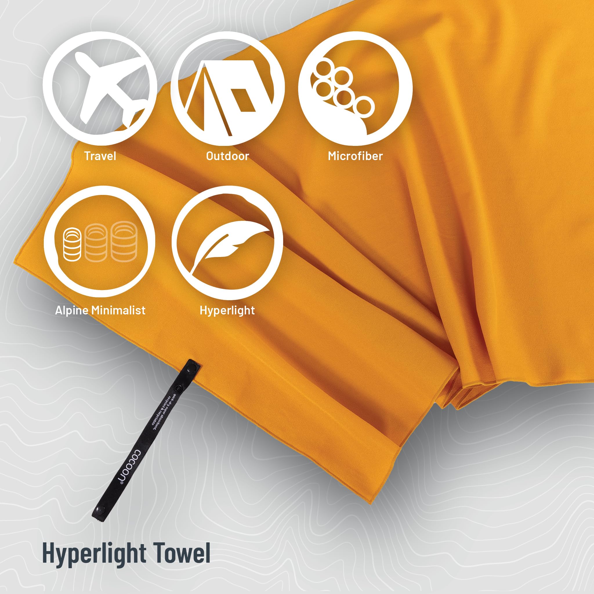 COCOON Hyperlight Towel Sunrise Small with strap for quick attachment to a bag.