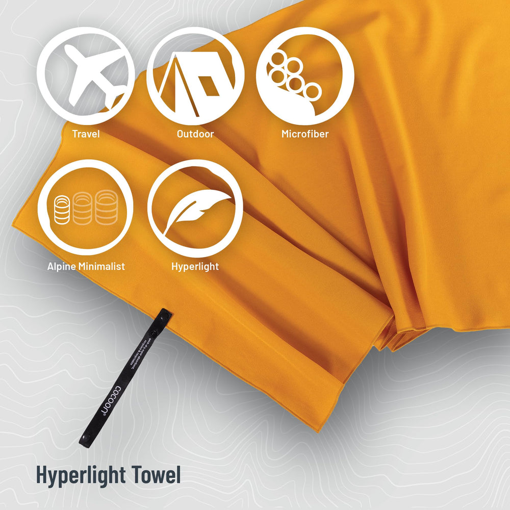 COCOON Hyperlight Towel Sunrise Small with strap for quick attachment to a bag.