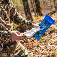 Applying Code Blue Field Wipes to face and neck during outdoor activity to refresh camouflage.