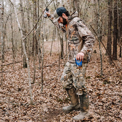 Code Blue Grave Digger Dripper hanging on a branch to deploy scent naturally.