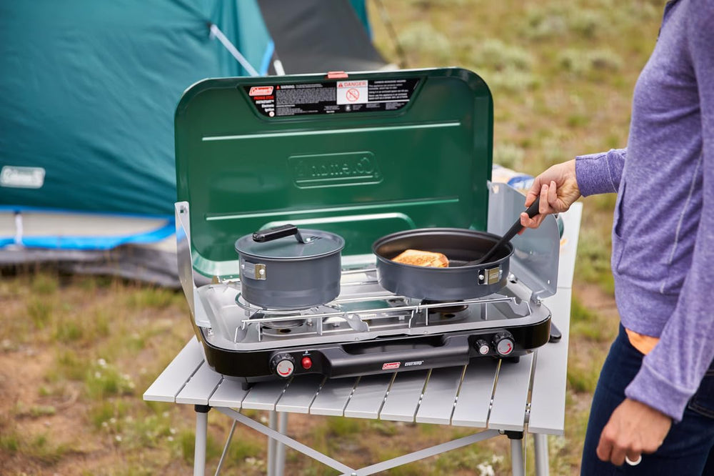 Wind-blocking panels shield burners while doubling as side tables.