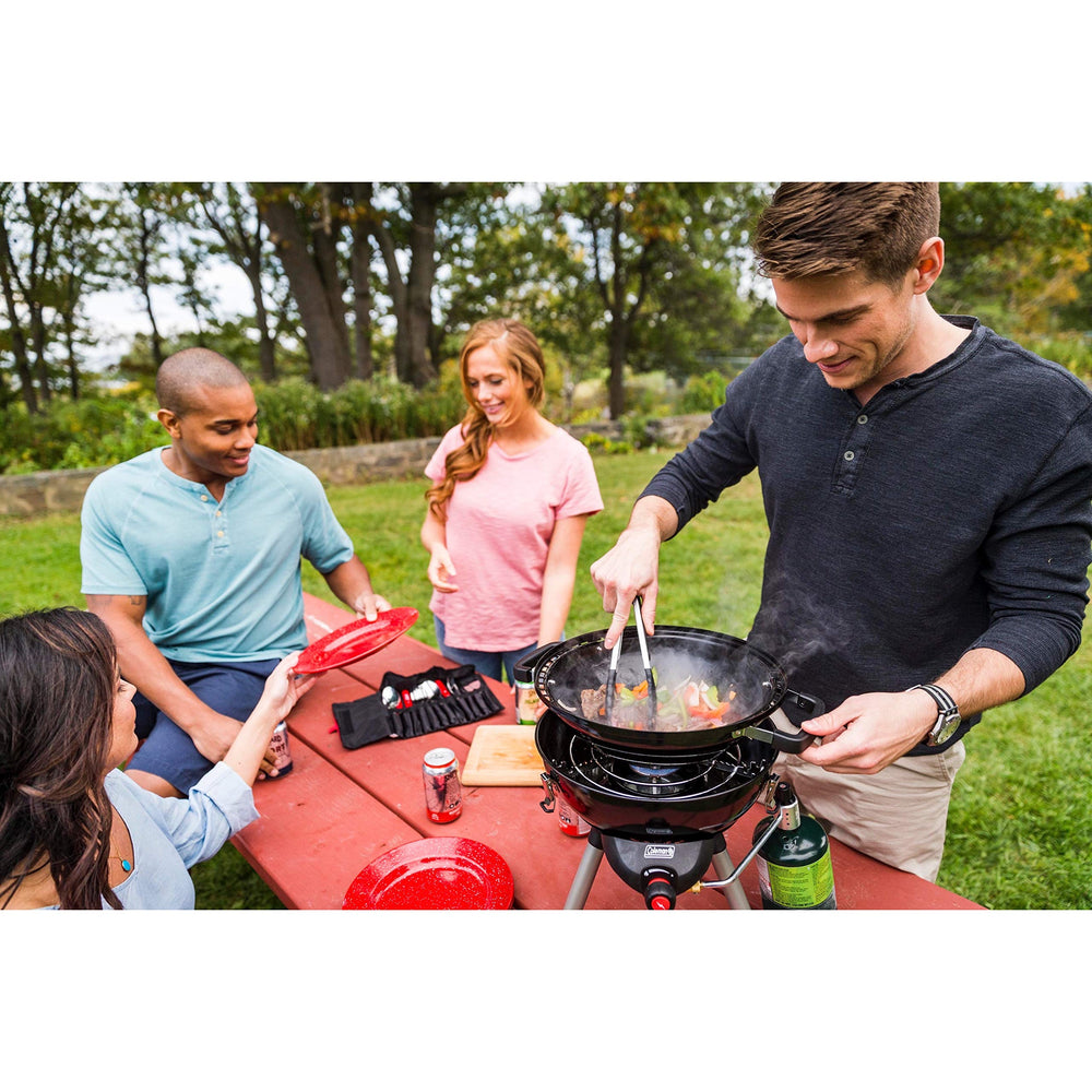 Coleman durable enamel dinnerware set shown outdoors on a picnic table.